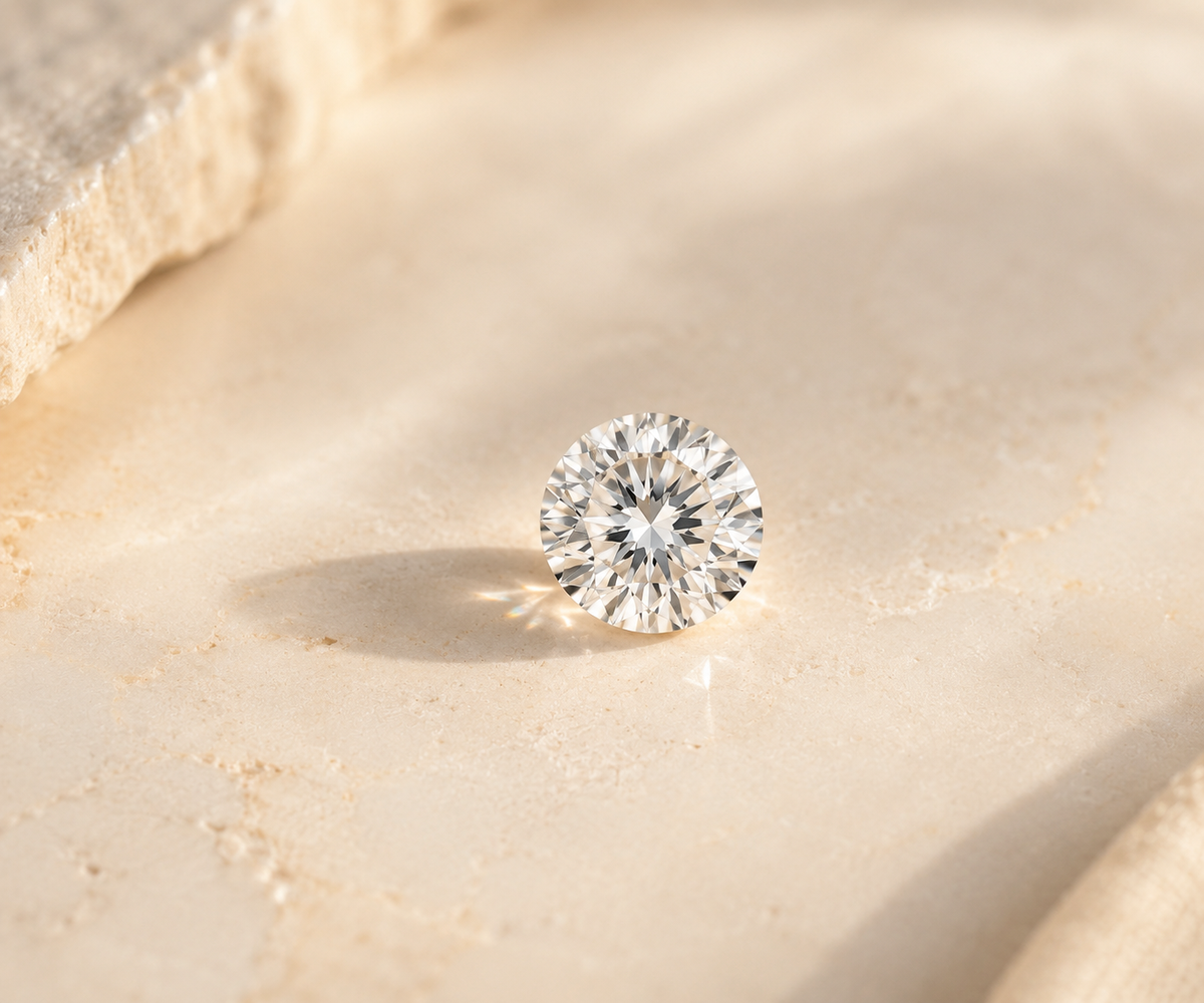 A loose round diamond standing on a softly lit natural stone surface.